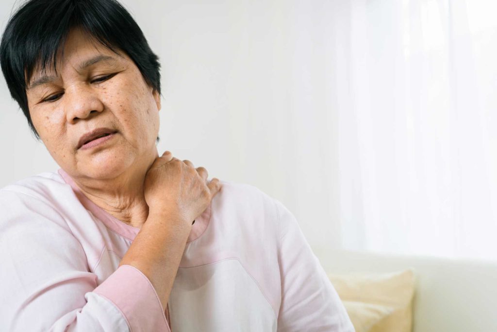 Woman holds neck in pain