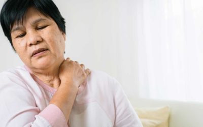 Woman holds neck in pain